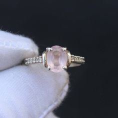 an engagement ring with a pink stone and diamond accents