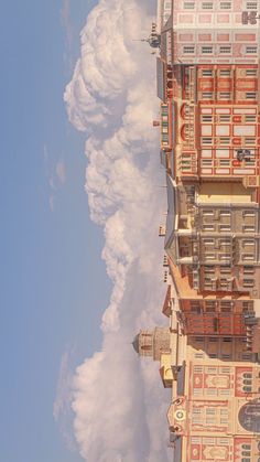 the building has many windows and balconies on it's sides as well as some clouds in the sky