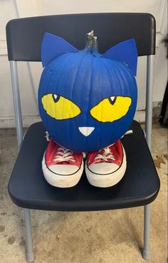 a blue cat pumpkin sitting on top of a black chair