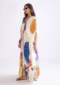 The shiloh kaftan features a vibrant tribal print in ivory and multi-colored hues. Crafted from luxurious habutai fabric, it includes a drawstring waistline that allows for a customizable fit, blending bold patterns with elegant, flowing design. Printed Kaftan, Tuxedo Accessories, Beach Wedding Guests, Jacket Cape, Ritu Kumar, Gown Skirt, Flow Design, Bold Patterns, Indian Fabric