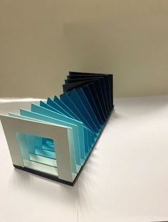 a stack of folded papers sitting on top of a white table