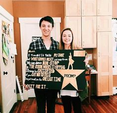 a man and woman holding up a sign in the shape of a star with words written on it