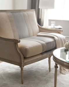 a living room scene with focus on the couch and chair in the foreground, along with a coffee table