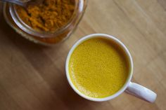 a cup filled with liquid next to a jar full of food