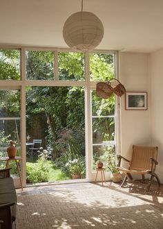 a living room filled with furniture and lots of glass doors that open up to the outside