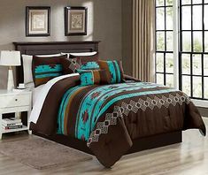 a bed with brown and blue comforters in a room