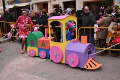 a child's colorful train is on display in front of a group of people