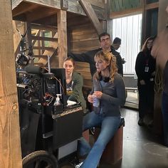 two women are sitting in front of a projector while others look at the camera