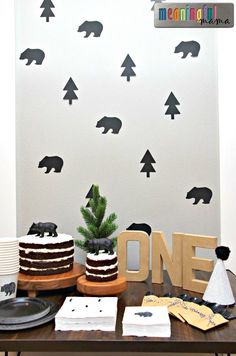 a table topped with two cakes covered in frosting and bears on the wall behind it