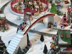 a model train set is shown with christmas decorations on the tracks and trees in the snow