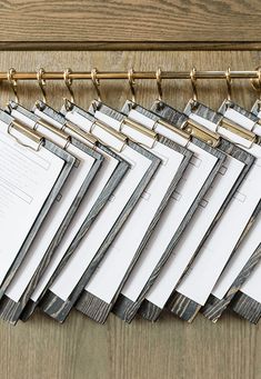 a bunch of papers sitting on top of a wooden table next to a metal rack