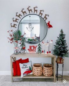 a decorated entryway with christmas decorations and decor on the wall, along with a round mirror