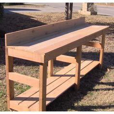 a wooden bench sitting on top of a grass covered field