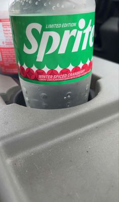 a bottle of sprite water sitting on the hood of a car