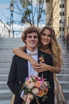 a young man and woman hugging each other on the steps