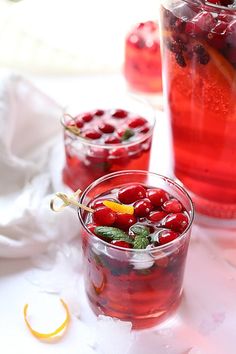 two glasses filled with cranberry punch and garnished with mint