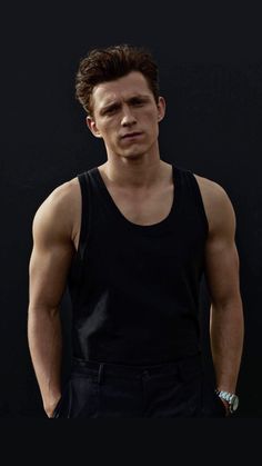 a man in black tank top standing with his hands on his hips