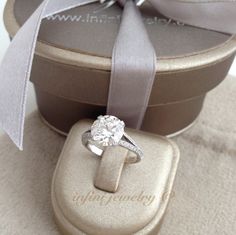 an engagement ring in a gift box with a bow