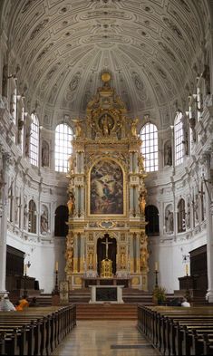 the inside of a church with pews and gold decorations