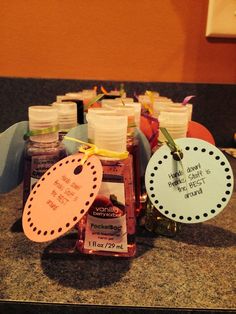 several bottles of hand sanitizers sitting on a counter with tags attached to them