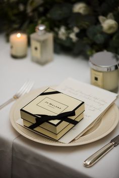 the table is set with white and black napkins, silverware, and candles