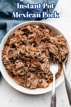 instant pot mexican pork in a white bowl with a fork and spoon next to it