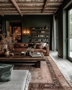 a living room filled with lots of furniture next to a large open window and wooden ceiling