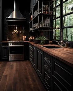 a kitchen with wooden floors and black cabinets