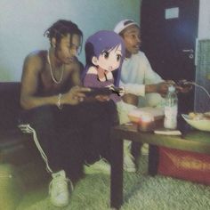 three people sitting on the floor in front of a table with an anime character cut out