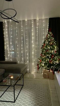 a living room with a christmas tree in the corner and lights on the wall behind it