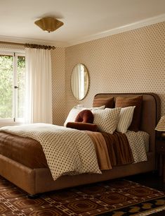 a bedroom with a bed, mirror and rug in it's centerpieces