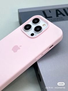 the pink iphone 11 is on display in front of a gray box with an apple logo