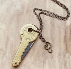 a gold key with a chain hanging from it's end on a wooden surface