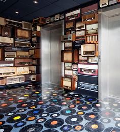 there is a room that has many old radio's on the walls and floor