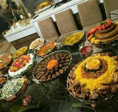 a table filled with lots of different types of food on top of glass trays