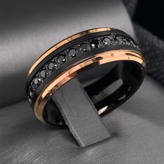 a black and gold wedding band with diamonds on the inside, set in 18k rose gold