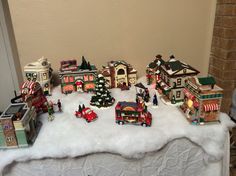 a table topped with lots of christmas decorations and figurines on top of snow covered ground