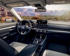 the interior of a car with mountains in the background