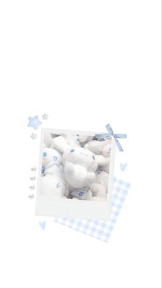 a box filled with white stuffed animals on top of a blue checkered table cloth