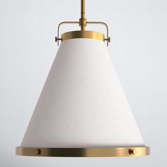 a white lamp hanging from the ceiling with a gold metal frame and fabric shade on it