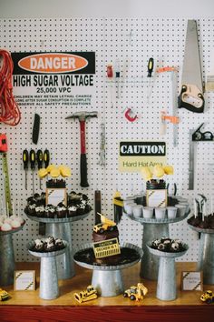 a table topped with lots of cakes and cupcakes on top of metal pans