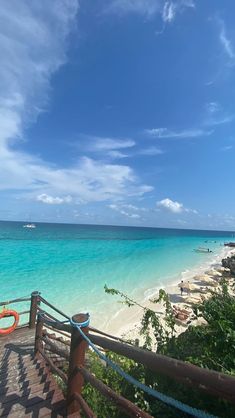 stairs lead down to the beach with boats in the water