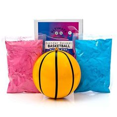 a yellow basketball sitting on top of a blue bag next to two bags with pink powder