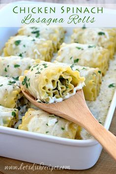 a wooden spoon filled with pasta and cheese covered in parmesan sauce, on top of a casserole dish