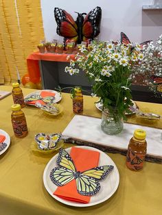 the table is set with orange and white plates, napkins, and honey bottles