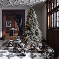 a christmas tree with silver balls on the floor