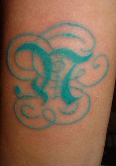 a tattoo on the arm of a woman with an elephant and swirly font in blue ink