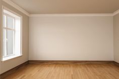 an empty room with white walls and wooden floors