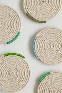 three round coasters with green and blue trim on white table top next to each other