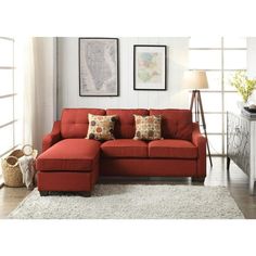 a living room with a red sectional couch and white rugs on the hardwood floor